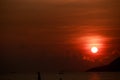 sun disk among red sky fishing boats on horizon at sunrise Royalty Free Stock Photo