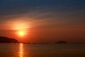 sun disk among red sky fishing boats on horizon at sunrise Royalty Free Stock Photo