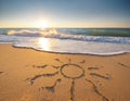 Sun drawing drawn on a beach at sunset