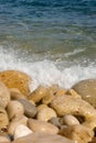 Sun-drenched beach in Alicante, Spain, featuring textured sea rocks in an array of shapes