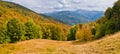Sun-drenched valley and mountains covered with forests with autumn colors Royalty Free Stock Photo