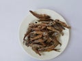 Sun dried fish and salty. small fish fried on white dish. top view and background. Royalty Free Stock Photo