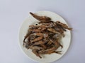 Sun dried fish and salty. small fish fried on white dish. top view and background. Royalty Free Stock Photo