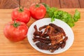 Sun-dried tomatoes on dish against the fresh tomatoes Royalty Free Stock Photo