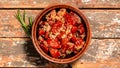 Sun dried tomatoes with fresh herbs and spices. Bowl of sun dried tomatoes garlic, oregano, olive oil on wooden background, top