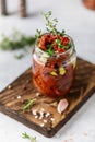 Sun dried tomatoes with fresh herbs and spices, sea salt in olive oil in a glass jar. Top view. Print for kitchen Royalty Free Stock Photo