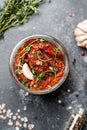 Sun dried tomatoes with fresh herbs and spices, sea salt in olive oil in a glass jar. Top view. Print for kitchen Royalty Free Stock Photo