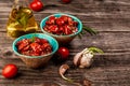Sun dried tomatoes with garlic, oregano, olive oil in a bowl. Delicious snack on wooden textured background, top view. space for Royalty Free Stock Photo