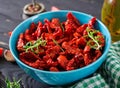 Sun dried tomatoes with herbs and garlic in bowl on wooden table. Royalty Free Stock Photo