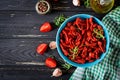 Sun dried tomatoes with herbs and garlic in bowl on wooden table. Royalty Free Stock Photo