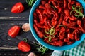 Sun dried tomatoes with herbs and garlic in bowl on wooden table. Royalty Free Stock Photo