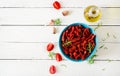 Sun dried tomatoes with herbs and garlic in bowl on wooden table. Royalty Free Stock Photo