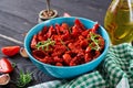 Sun dried tomatoes with herbs and garlic in bowl on wooden table. Royalty Free Stock Photo