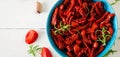 Sun dried tomatoes with herbs and garlic in bowl on wooden table. Royalty Free Stock Photo