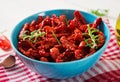 Sun dried tomatoes with herbs and garlic in bowl on wooden table. Royalty Free Stock Photo