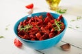 Sun dried tomatoes with herbs and garlic in bowl on wooden table. Royalty Free Stock Photo