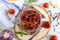 Sun-dried tomatoes with herbs, garlic in olive oil in a glass jar on a light background. Top view, flat lay Royalty Free Stock Photo