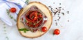 Sun-dried tomatoes with herbs, garlic in olive oil in a glass jar on a light background. Top view, flat lay Royalty Free Stock Photo