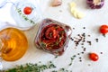 Sun-dried tomatoes with herbs, garlic in olive oil in a glass jar on a light background. Top view, flat lay Royalty Free Stock Photo