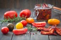 Sun dried tomatoes in olive oil with fresh herbs, spices and sea salt in a glass jar Royalty Free Stock Photo