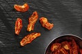 Sun dried tomatoes slices with Italian herbs and spices on dark background. Homemade dehydrated vegetable Royalty Free Stock Photo