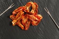 Sun dried tomatoes slices with Italian herbs and spices on dark background. Homemade dehydrated vegetable Royalty Free Stock Photo