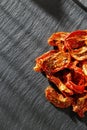 Sun dried tomatoes slices with Italian herbs and spices on dark background. Homemade dehydrated vegetable Royalty Free Stock Photo