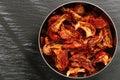 Sun dried tomatoes slices with Italian herbs and spices on dark. Homemade dehydrated vegetable Royalty Free Stock Photo