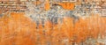 The sun-faded orange plaster on this brick wall crumbles, revealing layers of past craftsmanship. The vibrant orange Royalty Free Stock Photo