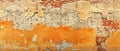 The sun-faded orange plaster on this brick wall crumbles, revealing layers of past craftsmanship. The vibrant orange Royalty Free Stock Photo