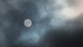 Sun filtered by dark clouds in the sky - looks like the moon but you can see sun spots - blue skies visible - as seen from Minneso Royalty Free Stock Photo