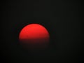 Fire red Sun filtered by forest fire smoke in evening sky