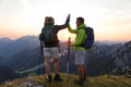SUN FLARE: Cheerful hikers high five after successfully climbing a mountain.