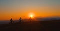 SUN FLARE: Golden evening sun rays illuminate three friends cross country biking