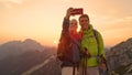 SUN FLARE: Newlyweds taking selfies after reaching the mountaintop at sunrise. Royalty Free Stock Photo