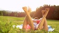 SUN FLARE: Unrecognizable barefoot man and woman lie in the serene countryside