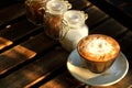 The sun foam design in hot latte coffee and suger on rough wooden table
