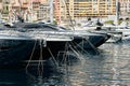 Sun glare on glossy board boats, azure water, tranquillity in port Hercules, bows of moored boats at sunny day