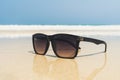Sun glasses lie on a beach near the sea Royalty Free Stock Photo