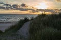 The sun goes down over the North Sea in Denmark - a dune with beach grass is in foreground Royalty Free Stock Photo