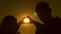 Sun in hand. teamwork of a loving couple. couple in love shows heart symbol with hands. Bride and groom making a heart Royalty Free Stock Photo