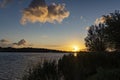 The sun has just appeared above the horizon and shines along the reeds and the bushes around lake Zoetermeerse Plas Royalty Free Stock Photo