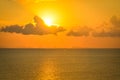 Sun hides behind clouds dramatic and colorful sunset at beach