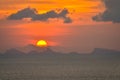 Sun hides behind clowds dramatic and colorful sunset at beach