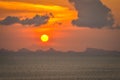 Sun hides behind clowds dramatic and colorful sunset at beach