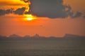 Sun hides behind clowds dramatic and colorful sunset at beach