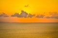 Sun hides behind clowds dramatic and colorful sunset at beach