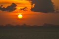 Sun hides behind clowds dramatic and colorful sunset at beach