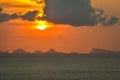 Sun hides behind clowds dramatic and colorful sunset at beach