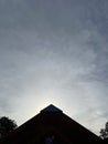 the sun hides behind a triangular building